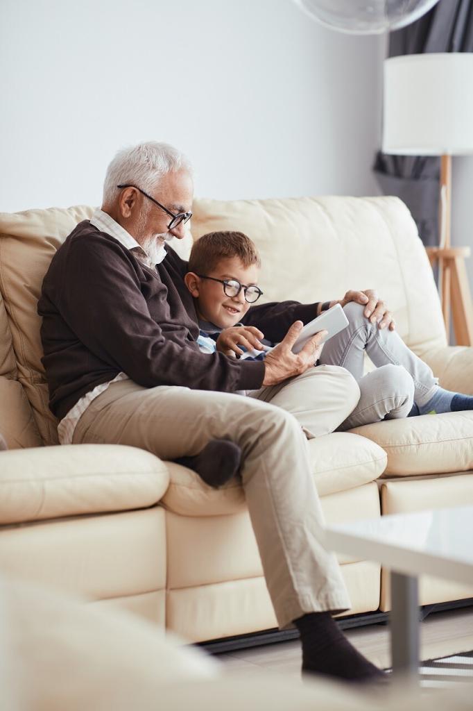 Un grand-père avec son petit fils dans le canapé